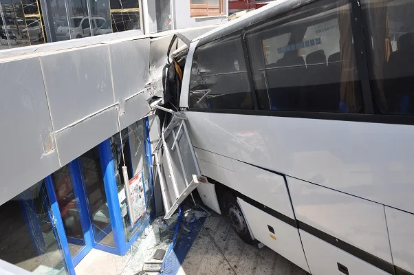 Silifke'de park halindeyken hareket eden otobüs, otomobile çarpıp markete girdi